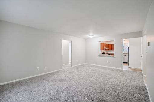A large empty room with a carpeted floor and white walls.