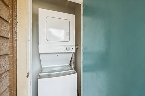 A white washing machine is installed in a small room.