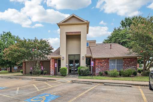 A parking lot with a handicap parking space in front of a building.