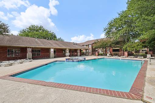 A large swimming pool surrounded by a brick border.