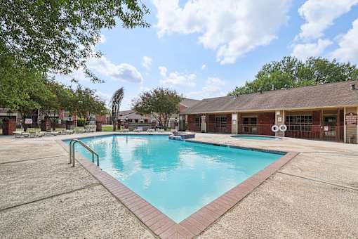 A large swimming pool in a sunny outdoor setting.