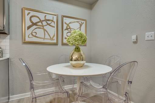 A dining room with a white table and chairs.