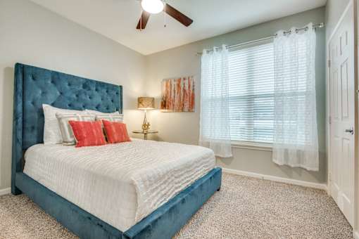 A bedroom with a large bed and a ceiling fan.