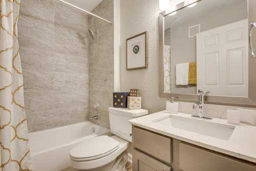 A bathroom with a white toilet, a white sink, and a shower curtain.