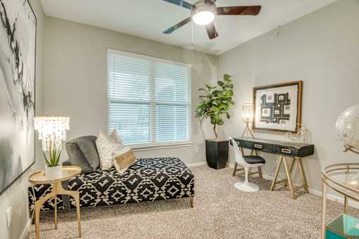 A room with a bed, desk, and chair.