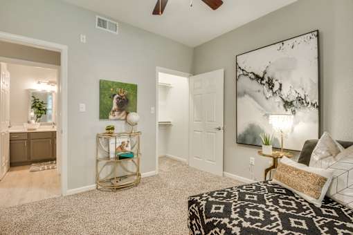 A bedroom with a large bed and a painting on the wall.