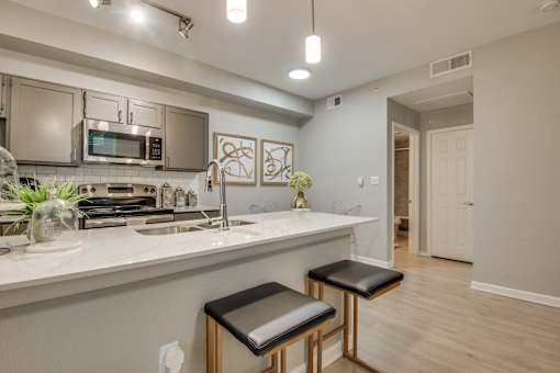A kitchen with a white countertop and a sink.