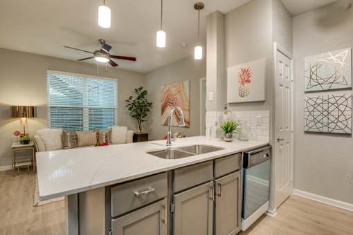 A kitchen with a white countertop and a ceiling fan.