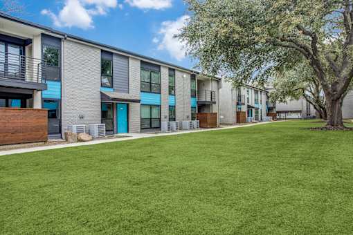 A grassy area in front of apartment buildings.