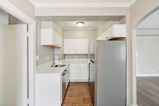 A kitchen with white appliances and cabinets.