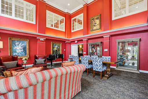 A living room with a piano and a striped couch.