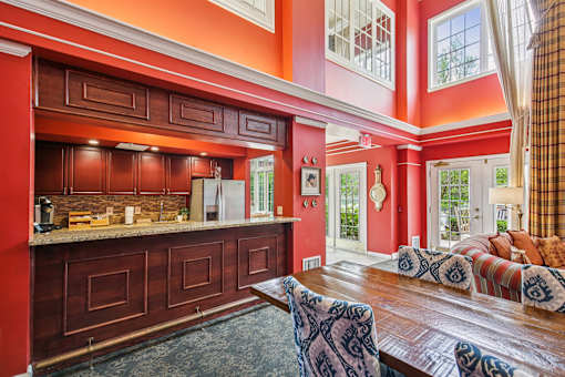 A kitchen with red walls and wooden cabinets.