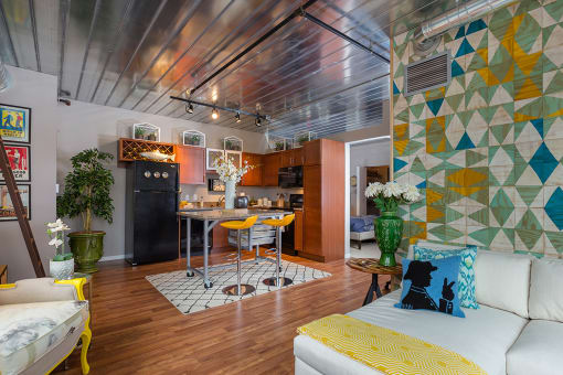 a living room with a kitchen and a yellow couch at Ann Arbor City Club, Ann Arbor Michigan