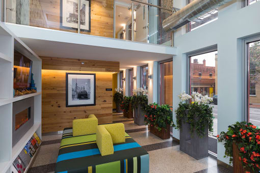 the lobby of a building with a colorful couch and plants at Ann Arbor City Club, Ann Arbor, 48104