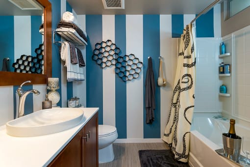 a bathroom with blue and white striped walls and a sink and toilet at Ann Arbor City Club, Michigan, 48104