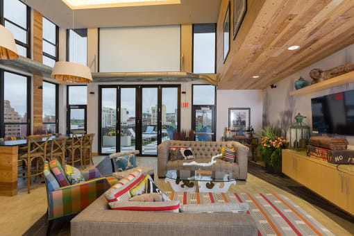 a living room with a couch and a table and windows at Ann Arbor City Club, Ann Arbor, MI