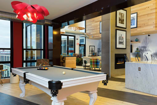 a pool table in a living room with a fireplace at Ann Arbor City Club, Ann Arbor