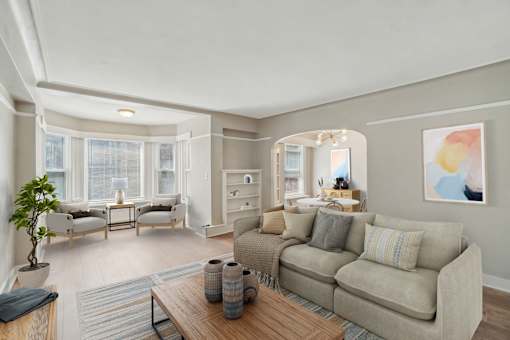 A living room with a couch, a coffee table, and a potted plant.