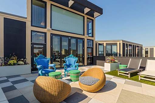 a patio area with chairs and tables outside of a building at Ann Arbor City Club, Ann Arbor