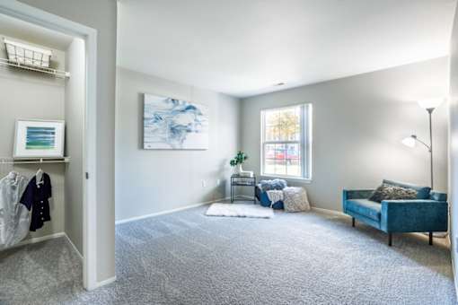 a living room with a couch and a chair and a window