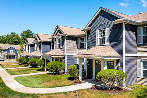 the view of a row of suburban homes on a sidewalk