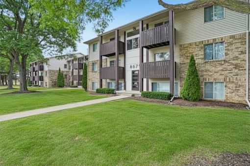 Apartment complex with a green lawn in front.