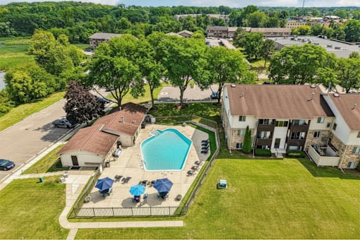A large grassy area with a swimming pool and a building in the background.