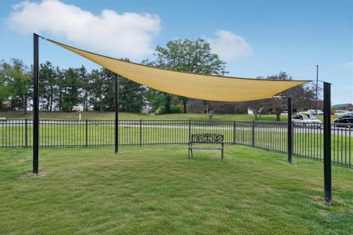 A park with a bench and a yellow canopy.