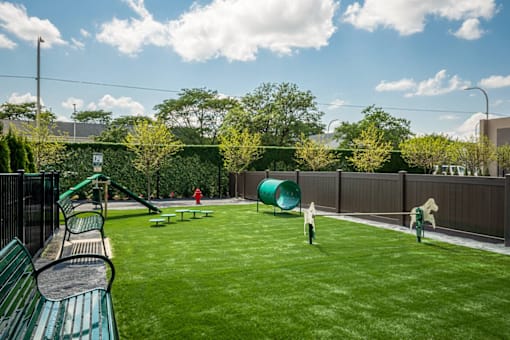 a backyard with a swing set and a playground at City Club Apartments Lafayette Park, Michigan