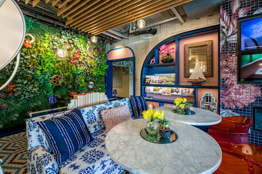 a living room with blue and white furniture and a green wall at City Club Apartments Lafayette Park, Michigan 48207