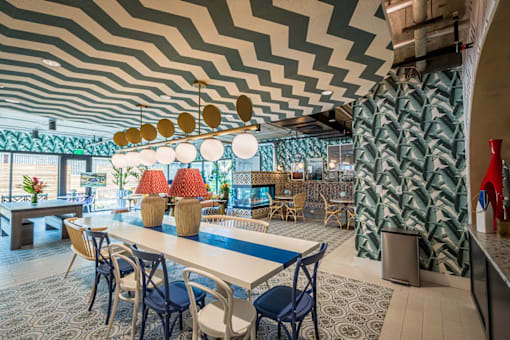 a dining room with a table and chairs and a geometric ceiling at City Club Apartments Lafayette Park, MI 48207