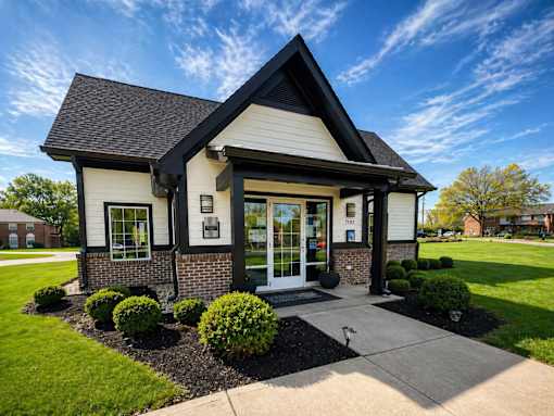 A small white building with a black roof and a glass door.