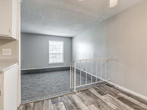 A room with a window and a wooden floor.