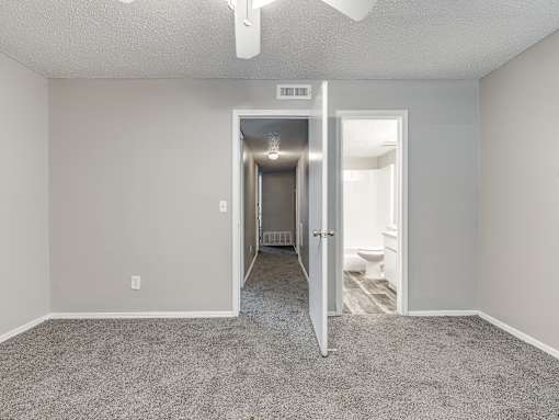 A room with a carpeted floor and a doorway leading to another room.