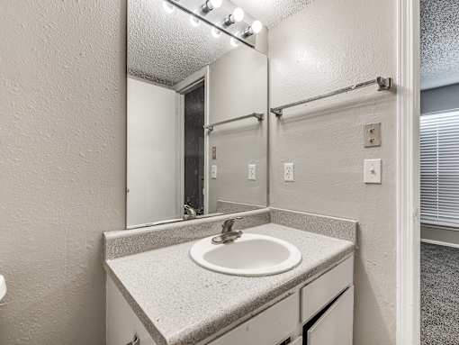 A bathroom with a sink and mirror.