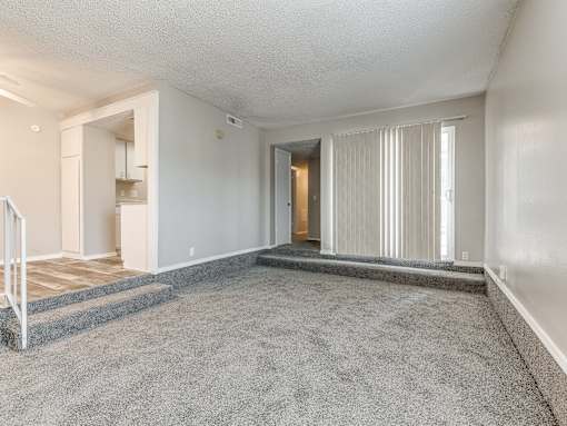 A spacious living room with a staircase leading to the upper floor.