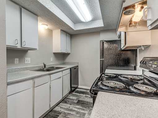 A kitchen with a stove top oven and a sink.