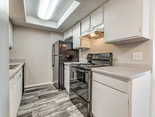 A kitchen with a black refrigerator, stove, and oven.