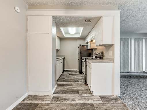 A kitchen with white cabinets and a tiled floor.