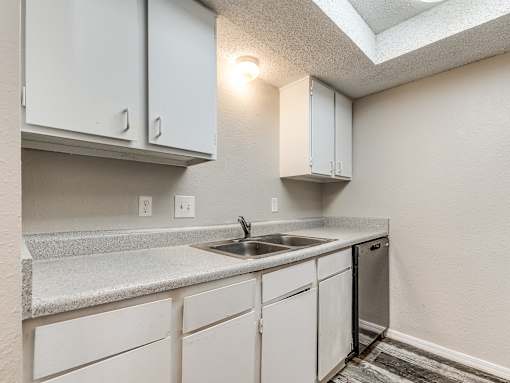 A kitchen with white cabinets and a granite countertop.