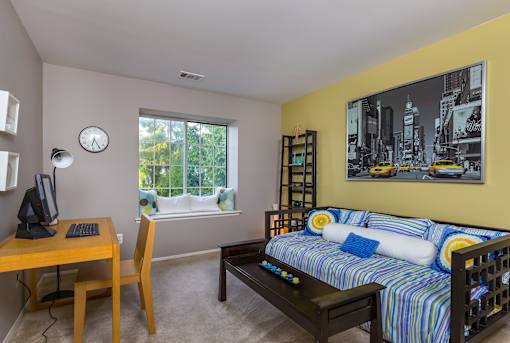 A room with a bed, desk, and chair.