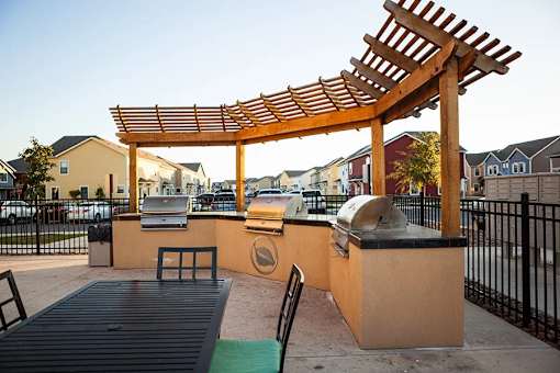 A wooden pergola is over a picnic table.