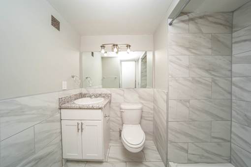 a bathroom with a toilet and a sink and a shower
