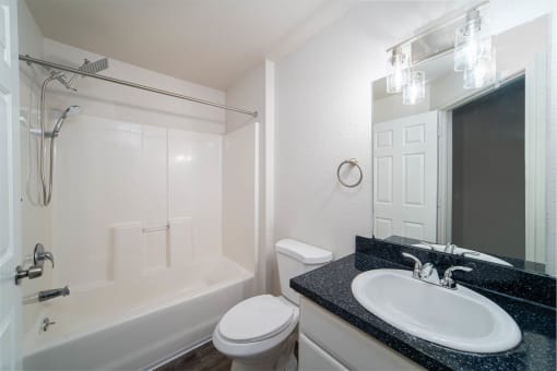 a bathroom with a sink toilet and shower and a mirror