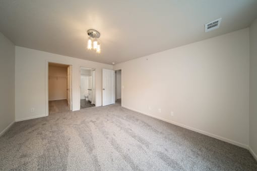 a spacious living room with carpet and white walls