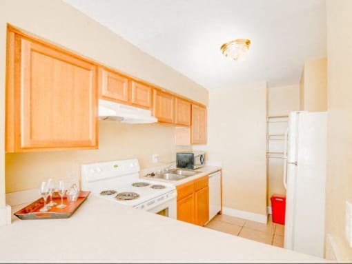 Kitchen with tan cabinets and white appliances.