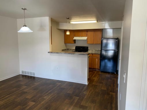 Kitchen and dining room with dark brown hardwood-like flooring.