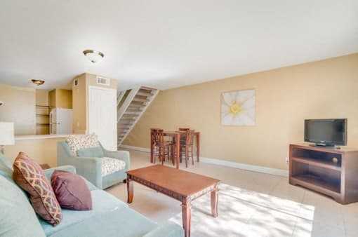 Living room and dining room with tile floor and neutral walls.