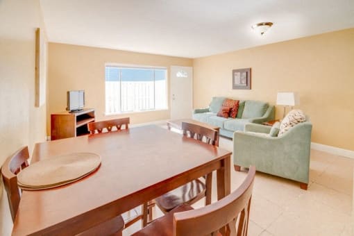 Dining room and living room with large picture window and tile flooring.