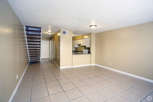 Living room and dining room with large tan tile flooring.